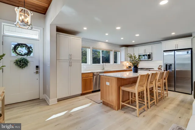 a kitchen with stainless steel appliances granite countertop a refrigerator and a stove top oven