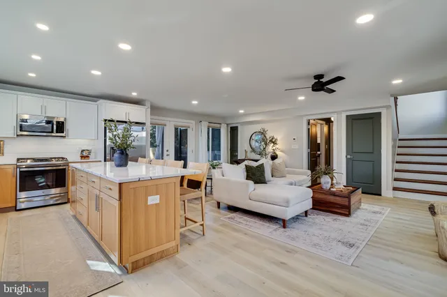 a living room with stainless steel appliances kitchen island furniture and a view of kitchen