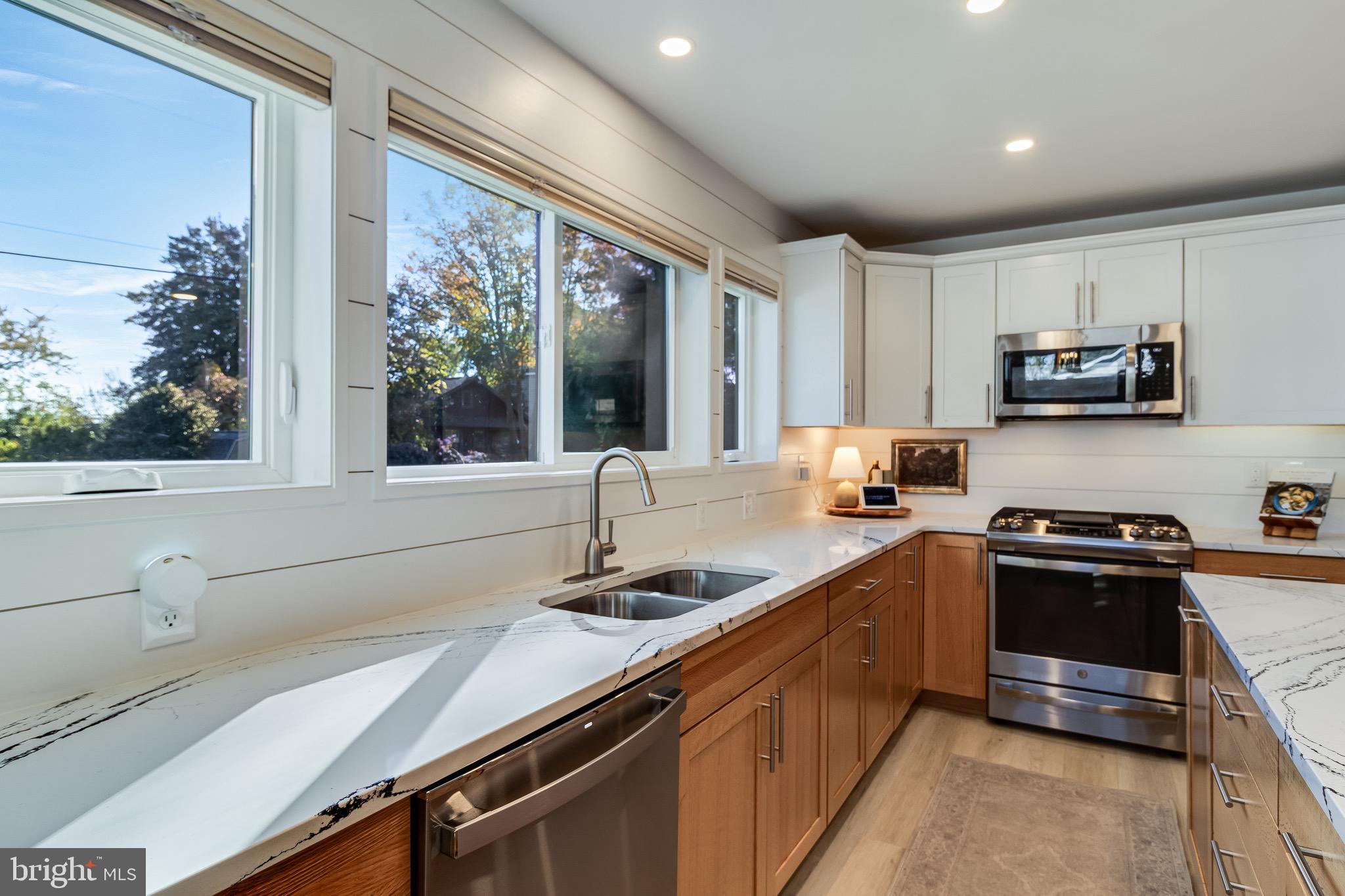 84 Chesapeake Avenue Prince Frederick, MD 20678 - Photo 7 of 42 a kitchen with stainless steel appliances granite countertop a sink a stove and a microwave