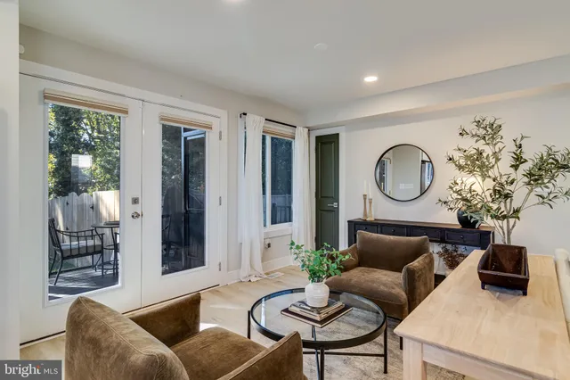 a living room with furniture kitchen view and a window