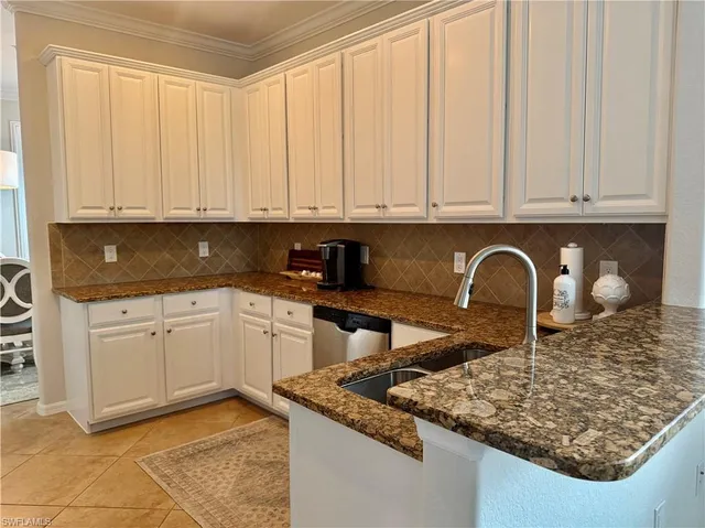 a kitchen with stainless steel appliances granite countertop a sink a stove white cabinets and a granite counter tops