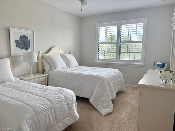 a bedroom with two beds and a window