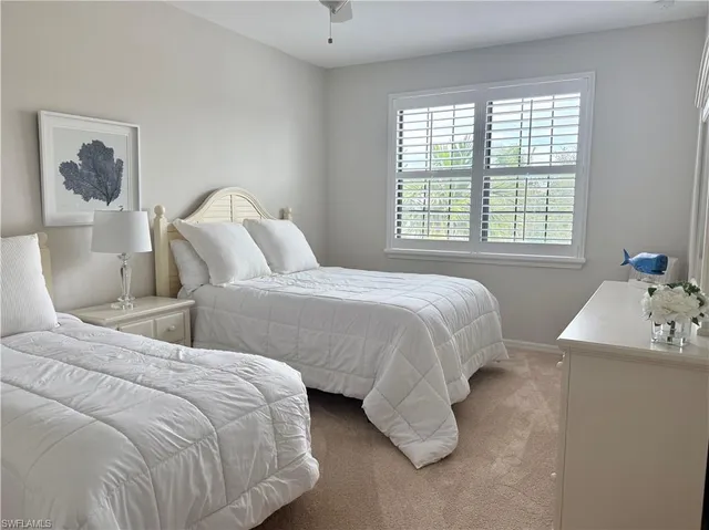 a bedroom with two beds and a window