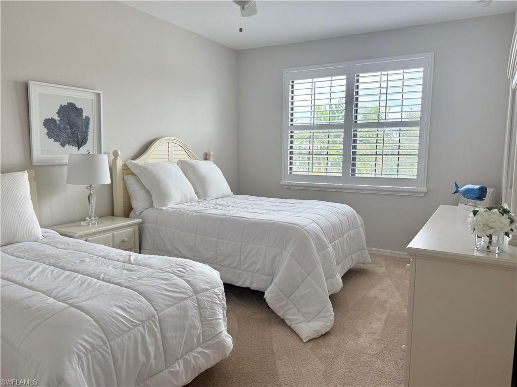 9498 Napoli Lane, Unit 201 Naples, FL 34113 - Photo 20 of 48 a bedroom with two beds and a window