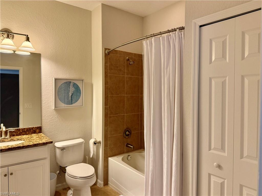 9498 Napoli Lane, Unit 201 Naples, FL 34113 - Photo 21 of 48 a white toilet sitting next to a bathroom sink