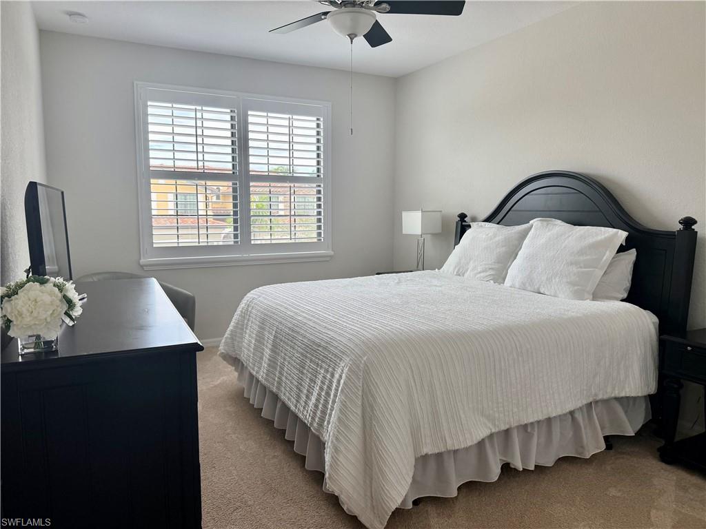 9498 Napoli Lane, Unit 201 Naples, FL 34113 - Photo 23 of 48 a bedroom with a bed and dresser