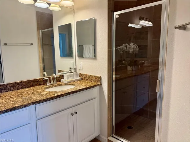 a bathroom with a granite countertop sink and a mirror