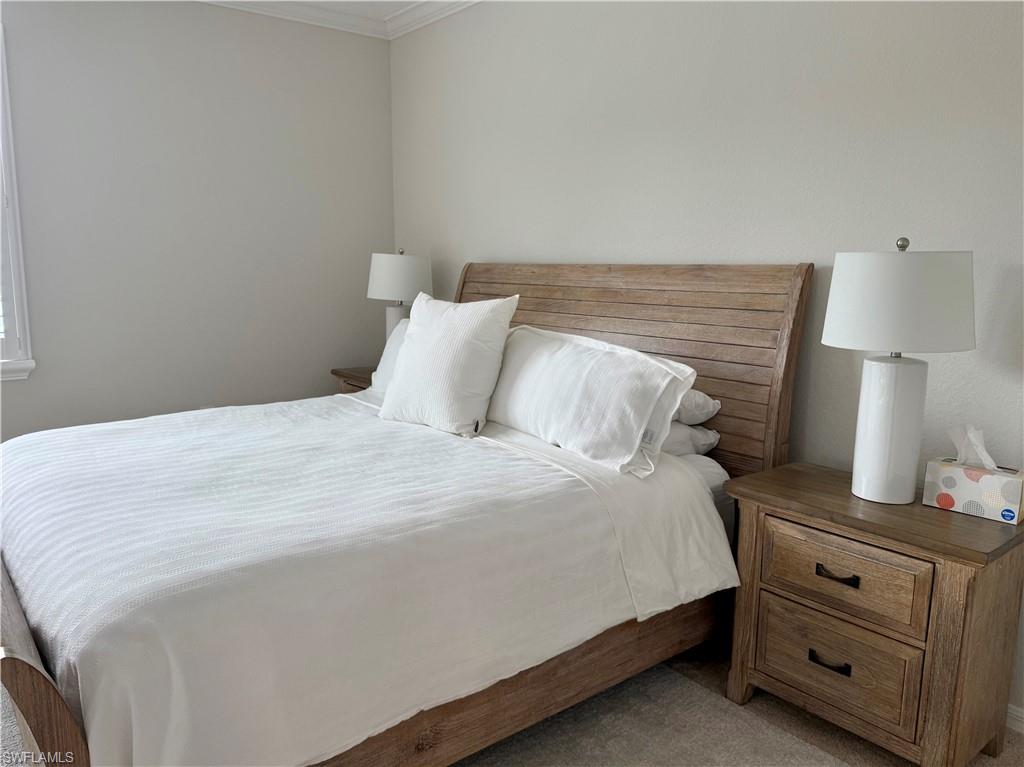 9498 Napoli Lane, Unit 201 Naples, FL 34113 - Photo 32 of 48 a bedroom with a bed and a lamp