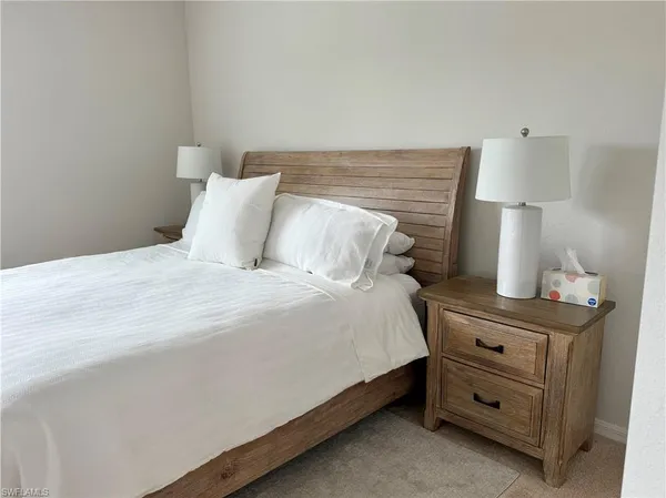 a bedroom with a bed and a lamp on the dresser