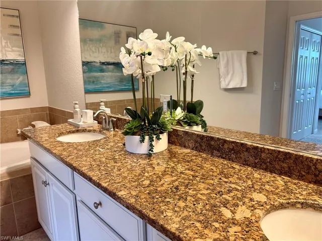 a bathroom with a granite countertop sink a mirror and a shower