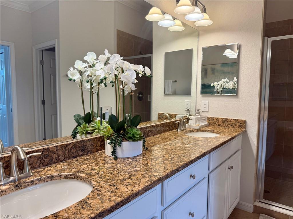 9498 Napoli Lane, Unit 201 Naples, FL 34113 - Photo 38 of 48 a bathroom with a sink a vanity and mirror