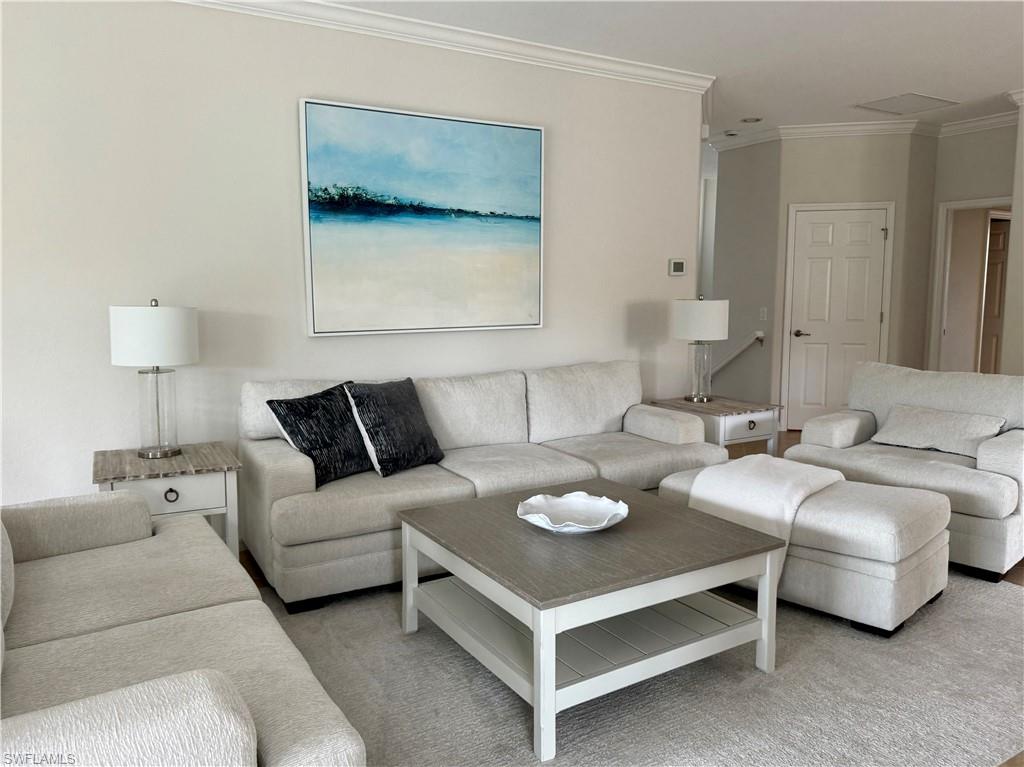 9498 Napoli Lane, Unit 201 Naples, FL 34113 - Photo 42 of 48 a living room with furniture and a lamp