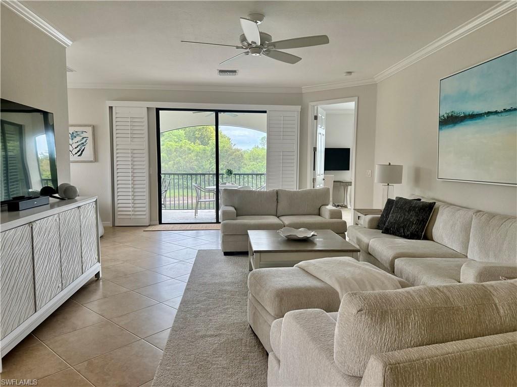 9498 Napoli Lane, Unit 201 Naples, FL 34113 - Photo 10 of 48 a living room with furniture and a flat screen tv