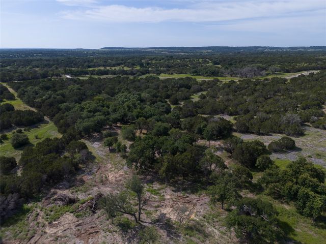 an aerial view of residential houses with outdoor space and trees