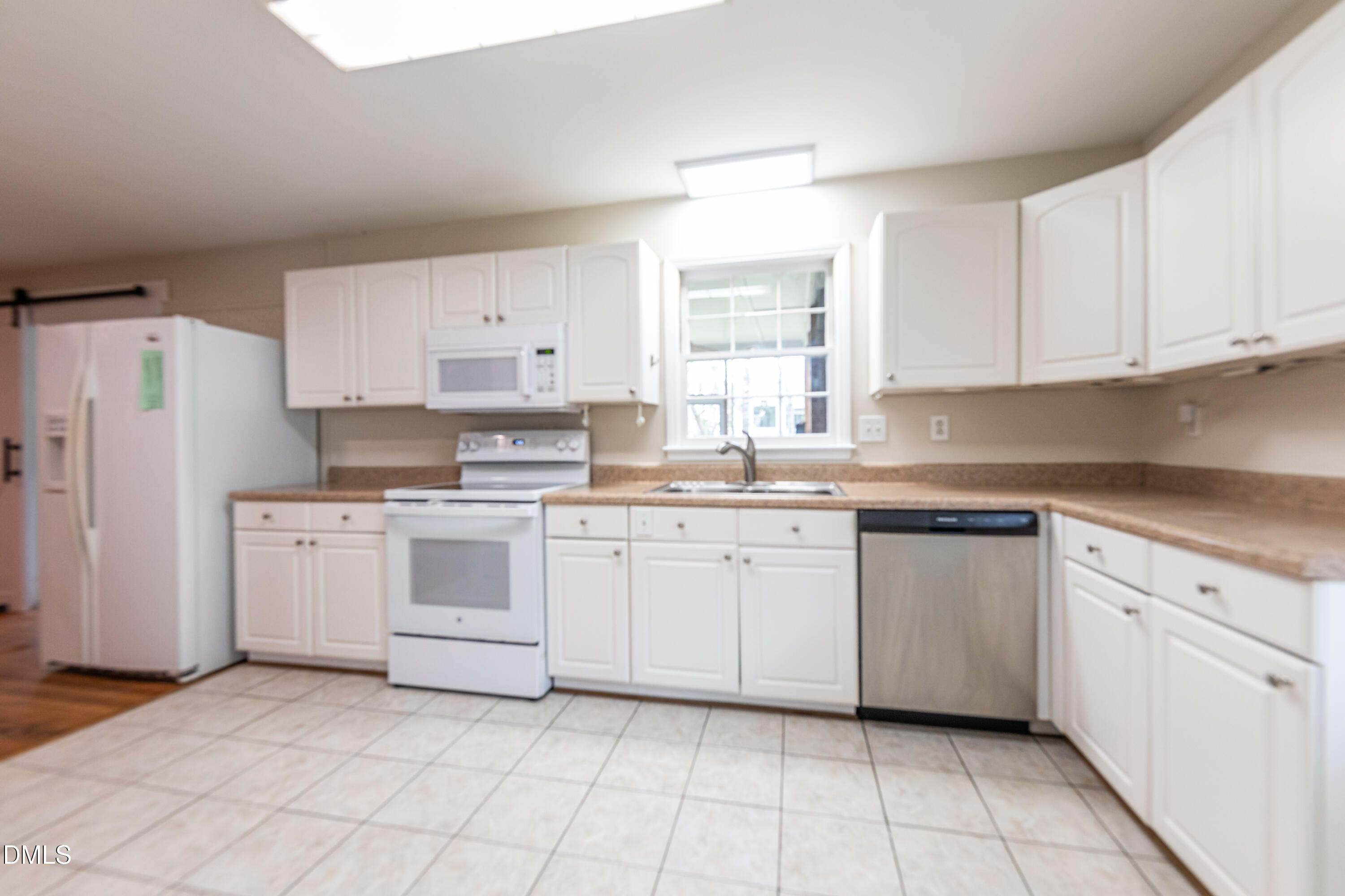 408 Ortega Road Raleigh, NC 27609 - Photo 7 of 25 a kitchen with cabinets appliances a sink and a window