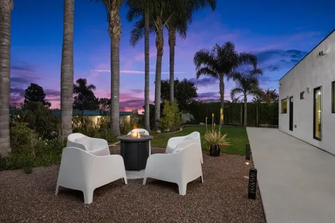 a view of a patio with couches and a table and chairs under an umbrella