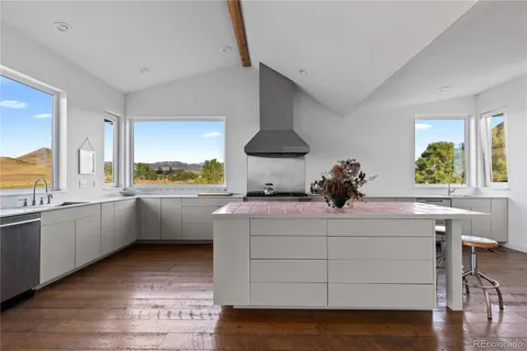 a kitchen with stainless steel appliances a white cabinets and a wooden floor