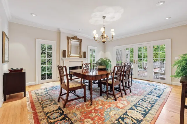 a kitchen with stainless steel appliances granite countertop a stove a sink a refrigerator and a dining table with wooden floor