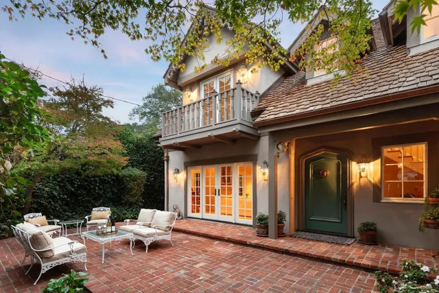 a view of a chair and tables in the patio in front of a house