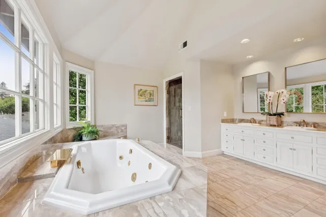 a view of bathroom with mirror and window