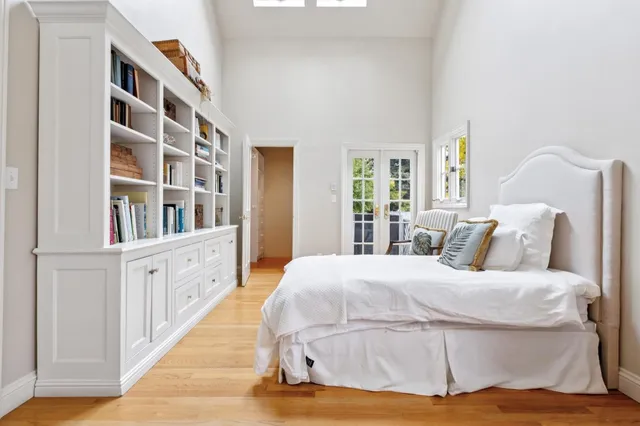 a bed sitting in a spacious bedroom next to a window