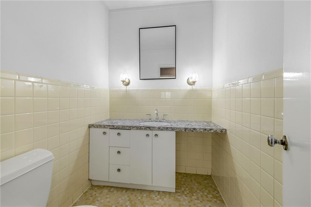 490 Maple Street Cornelia, GA 30531 - Photo 41 of 88 a bathroom with a granite countertop sink a toilet and mirror