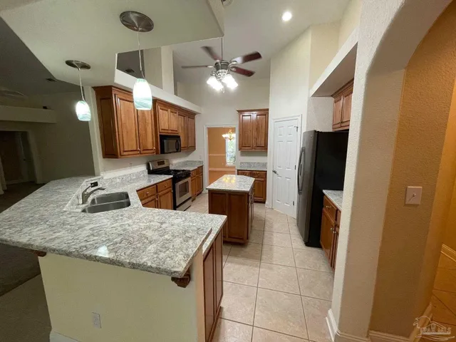 a kitchen with stainless steel appliances granite countertop a sink a refrigerator and a microwave