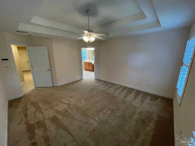 en empty room with windows and fan