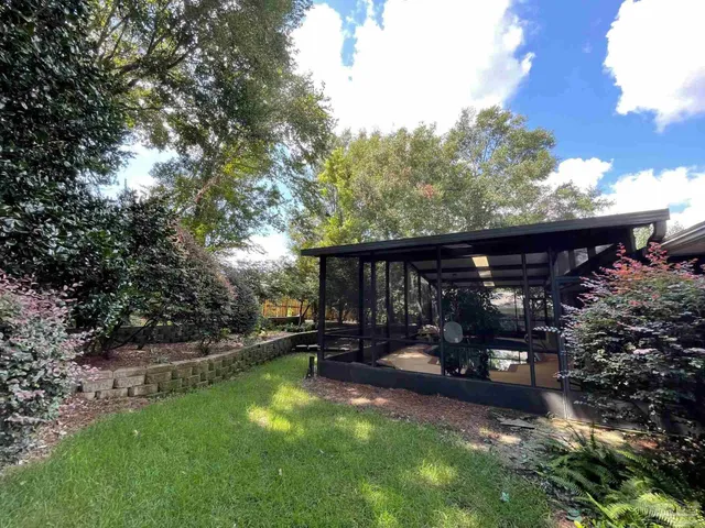 a view of a house with backyard and sitting area