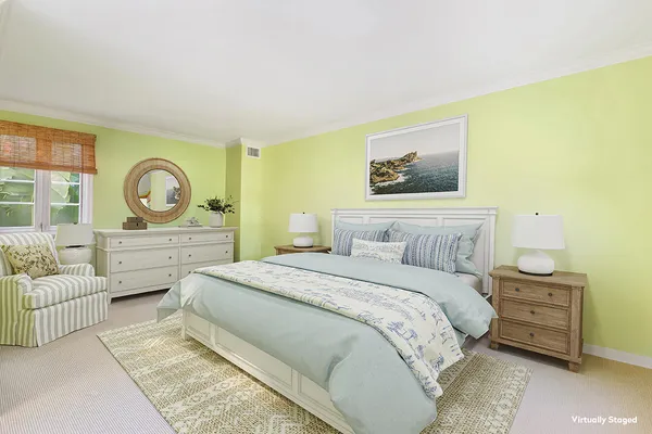 a spacious bedroom with a bed a couch and dresser