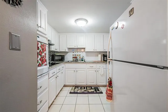 a kitchen with stainless steel appliances granite countertop a refrigerator and a stove