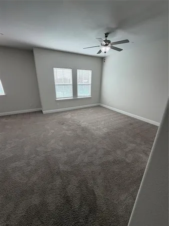 an empty room with a ceiling fan and window