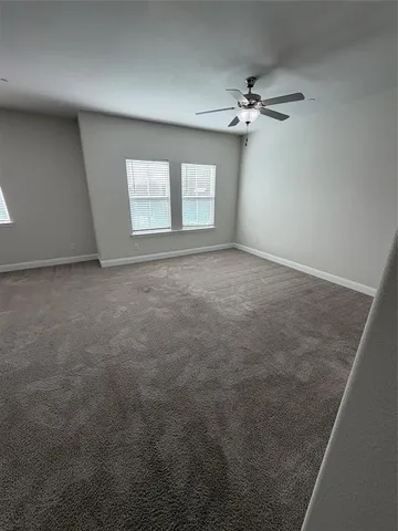 an empty room with a ceiling fan and window