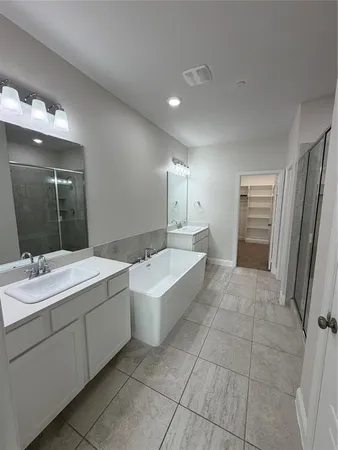 a bathroom with a bathtub sink and mirror