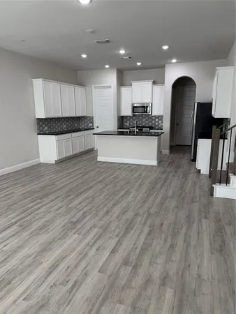 a view of kitchen with stove and cabinets