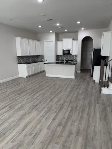 a view of kitchen with stove and cabinets