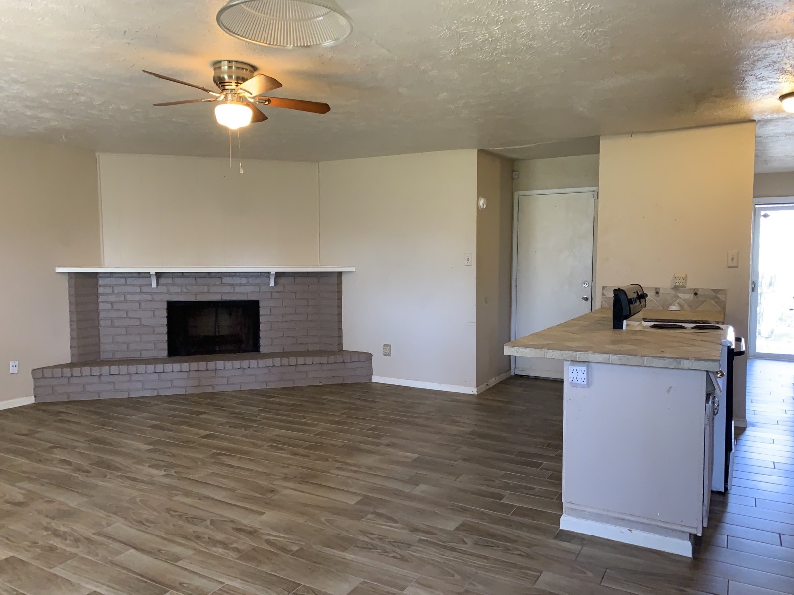 16118 Lazy Ridge Road Houston, TX 77053 - Photo 11 of 23 a view of an empty room with a fireplace and a chandelier fan