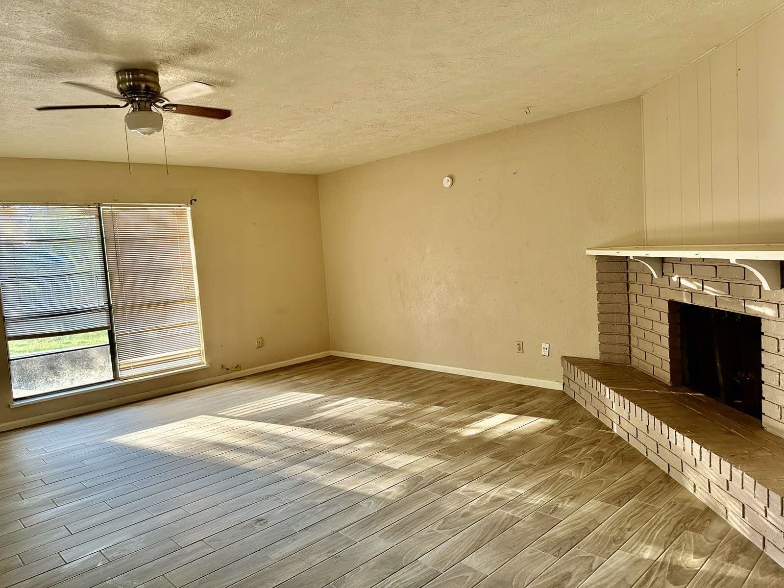 16118 Lazy Ridge Road Houston, TX 77053 - Photo 6 of 23 a view of empty room with a fireplace and wooden floor