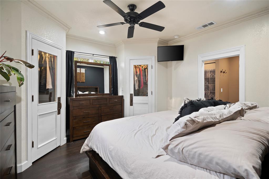 202 North Kickapoo Street Lipan, TX 76462 - Photo 21 of 38 Dark wood-finish flooring, white trim, crown molding, and a ceiling fan with integrated lighting