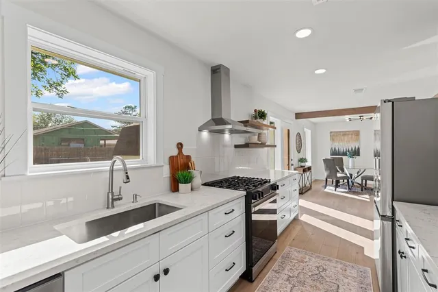 a kitchen with stainless steel appliances a stove a sink and a refrigerator