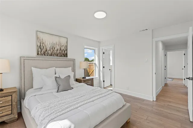 a bedroom with a bed and a painting on the wall