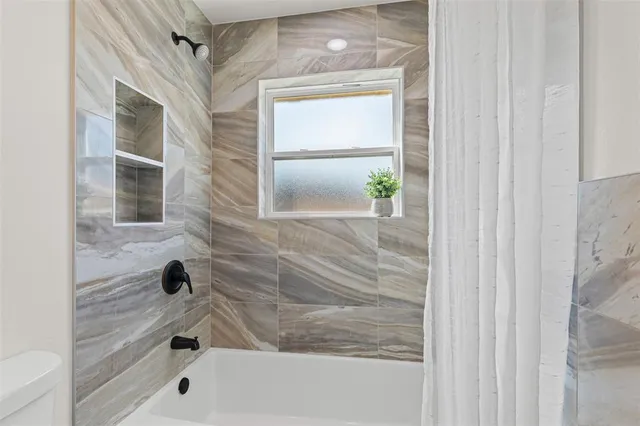 a bathroom with a bathtub and shower