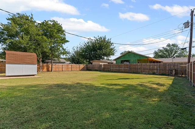 a front view of house with yard and trees in the background