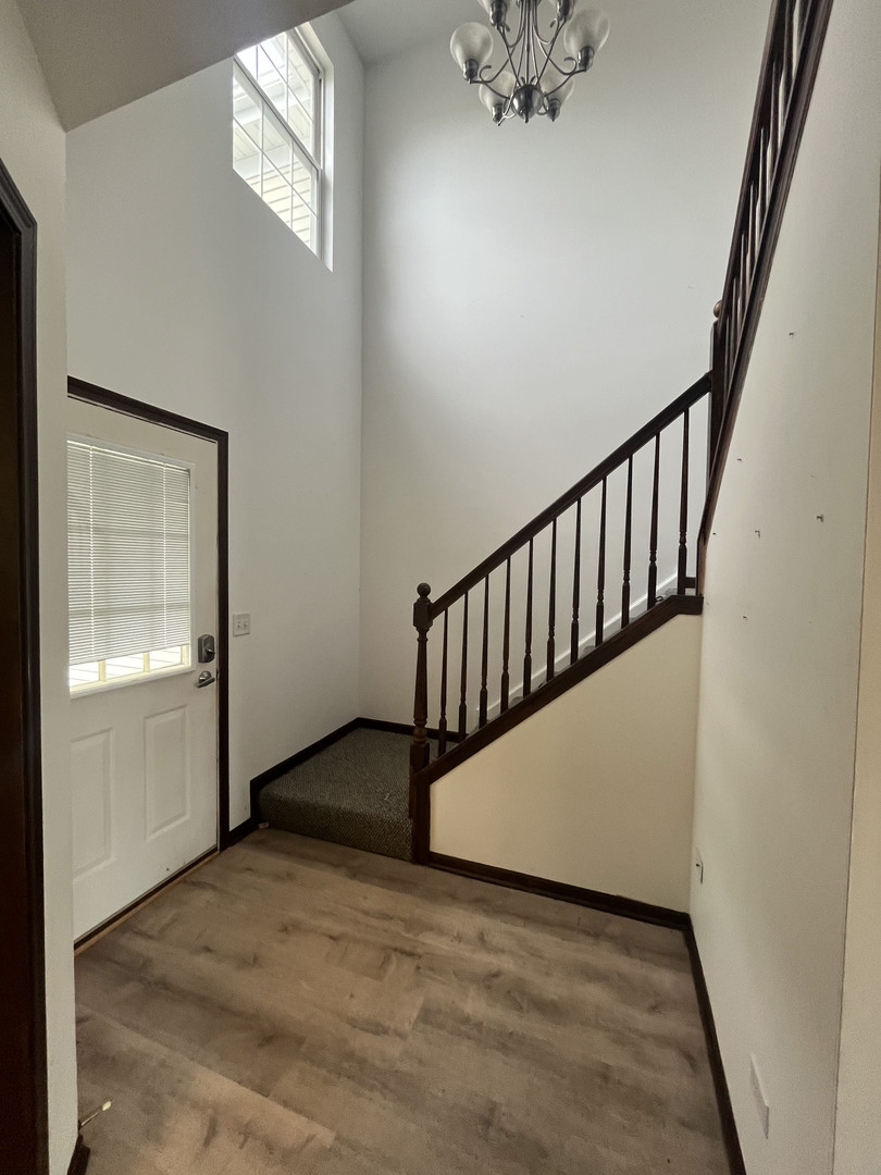 506 Prairie View Drive, Unit 506 Minooka, IL 60447 - Photo 11 of 12 a view of a hallway with wooden floor and staircase