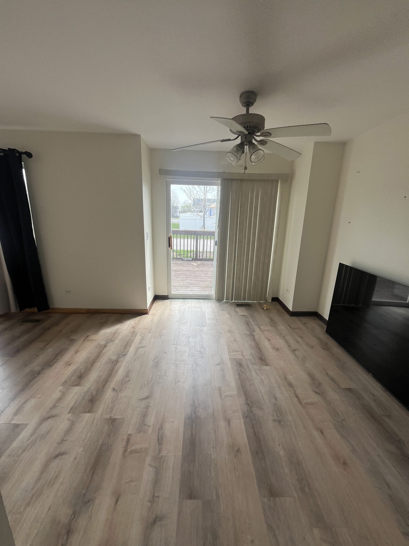 506 Prairie View Drive, Unit 506 Minooka, IL 60447 - Photo 10 of 12 wooden floor in an empty room with a window