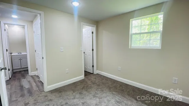 a view of a big room with wooden floor and a kitchen