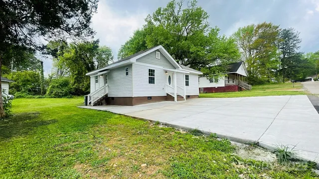 a view of a house with a yard and potted plants