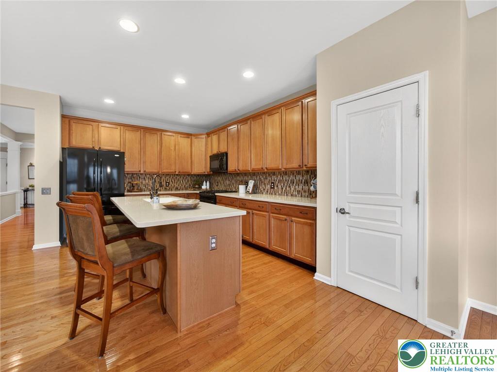 8611 Cascade Road Breinigsville, PA 18031 - Photo 21 of 40 a kitchen with stainless steel appliances granite countertop a table chairs sink refrigerator and cabinets