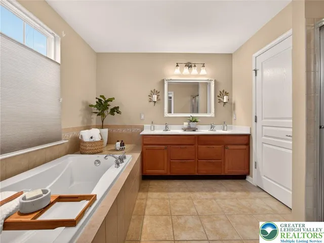 a bathroom with a tub sink and mirror