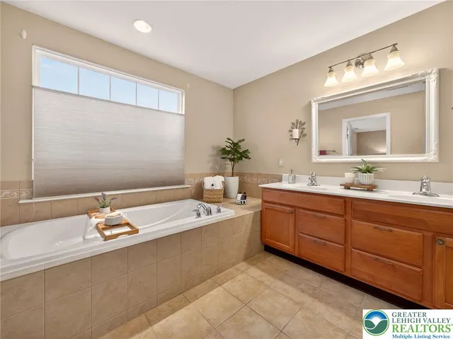 a spacious bathroom with a granite countertop tub sink and mirror
